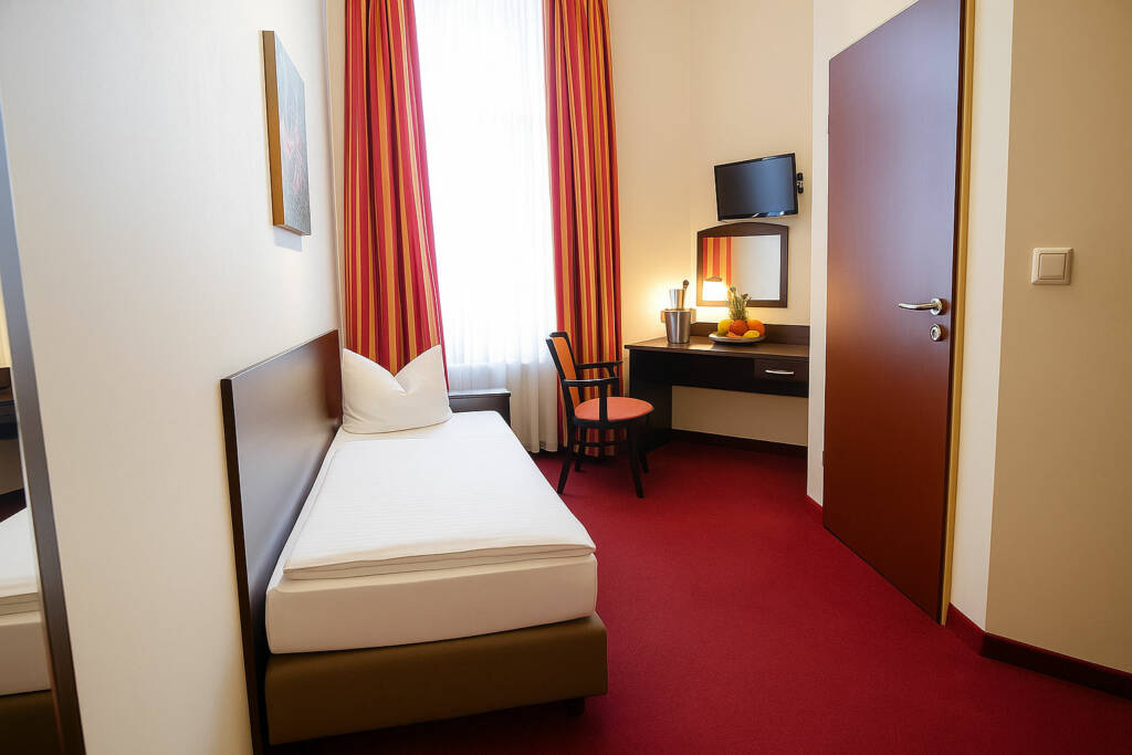 Einzelzimmer mit Bett und Schreibtisch